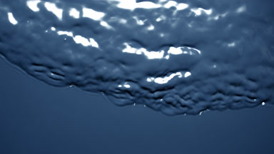 Macro shot of small waves on dark-blue opaque liquid surface