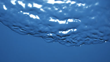 Macro shot of small waves on blue opaque liquid surface