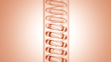 Clear liquid in vertical coil condenser on beige ramp background