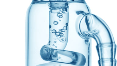 Pale blue liquid bubbles condense in glass tube, lab process