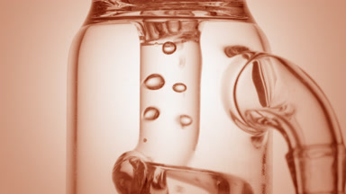 Clear liquid in glass tube, bubbles move chaotically, beige ramp
