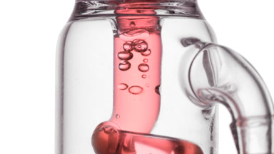 Roselle tea infusion in glass tube, bubbles condense and swirl