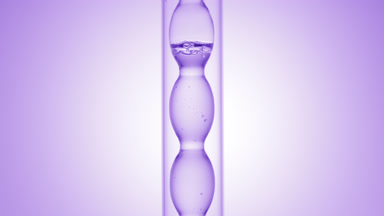 Pale violet liquid in bulb condenser on purple ramp background