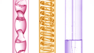 Pink, yellow, violet liquids bubble in bulb condenser, white bg