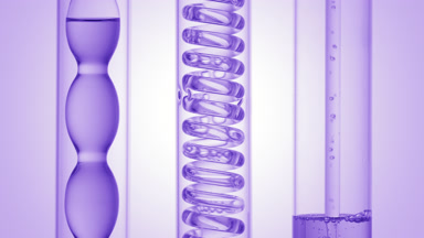 Violet liquids bubbling in condenser filling tube on purple ramp