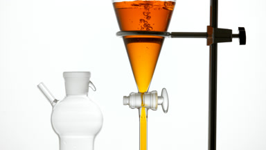 Rosehip extract pours in funnel, bubbles rising underwater