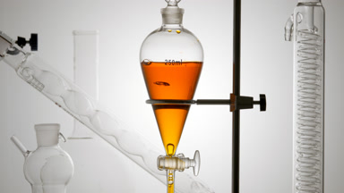 Honey water drains from funnel, rising bubbles, opened valve