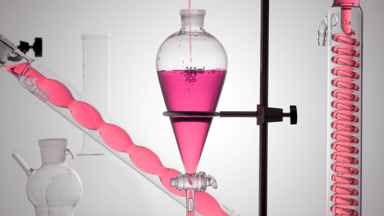 Pink transparent liquid pours into funnel, bubbles flows in coil