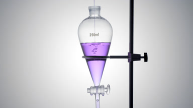 Violet liquid poured in funnel, bubbles rise on grey ramp