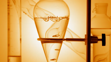 Clear liquid with air bubbles rising on yellow ramp background