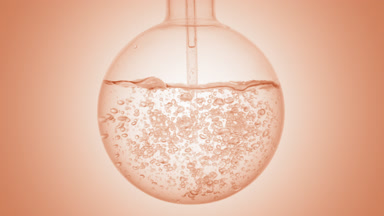 Clear liquid dropper injection swirls in flask, beige ramp base