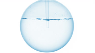 Oxygenated water dropper into round flask, swirling bubbles form