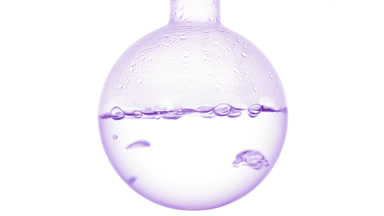 Clear liquid boils in round flask, condensing on white