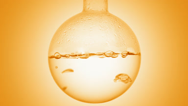 Clear liquid boiling in flask, condensation on orange ramp bg