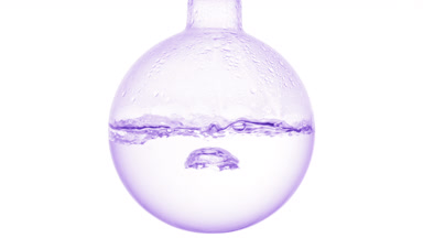 Clear liquid boiling in round flask, condensation on white bg
