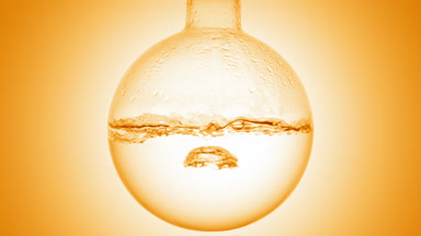 Clear liquid boiling in flask, condensation on orange ramp bg