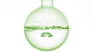 Clear transparent liquid boiling in flask, condensation white