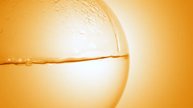 Orange hydrosol boiling in flask, bubbles and condensation