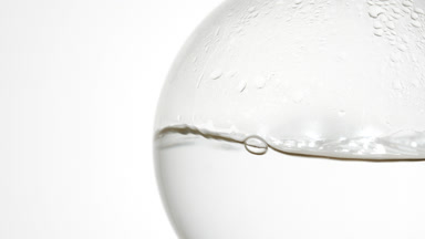 Ginger hydrosol boiling in flask, bubbles and condensation