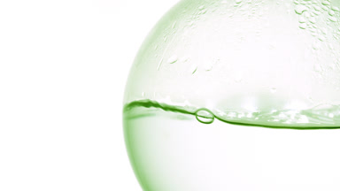 Clear transparent liquid boiling in flask, bubbles on white