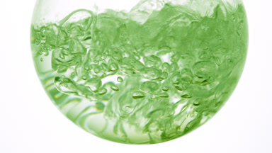 Clear liquid boiling in flask, bubbles on white background