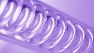 Clear liquid spirals in lab condenser on purple ramp background