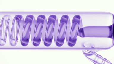 Violet liquid fills coli condenser in glass tube on white