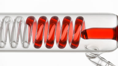 Hibiscus infusion fills horizontal coil condenser in glass tube