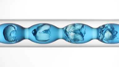 Blue liquid fills and drains from bulb condenser, white backdrop