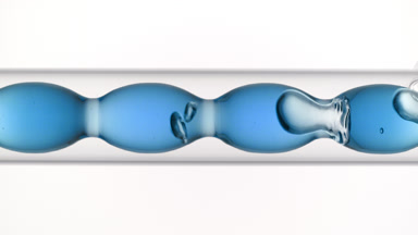 Blue tansy hydrosol fills and drains from bulb condenser glass