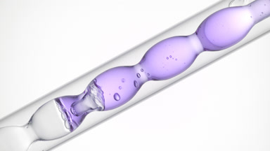 Pale violet liquid in inclined bulb condenser, white background