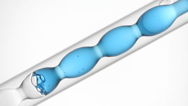 Pale blue liquid in inclined bulb condenser, white background