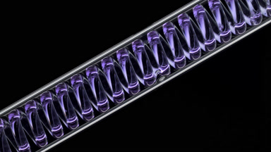Violet liquid in inclined coil condenser on black background