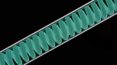 Cyan liquid in inclined coil condenser on black background lab