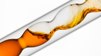 Orange liquid poured into inclined bulb condenser, white