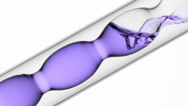 Lavender hydrosol pouring into inclined bulb condenser in lab