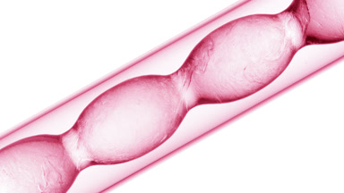 Liquids of different densities mixing in pink flask on white