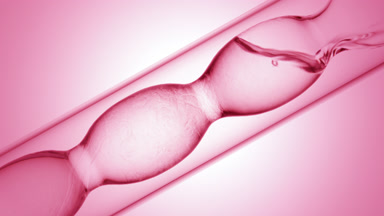 Pink liquids of varying density mixing in flask, swirls on pink