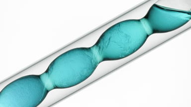 Cyan liquids mixed in flask, refractive swirls, schlieren effect