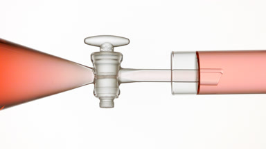 Cranberry extract flows from funnel into test tube, filling up