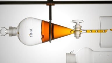 Orange liquid drains from funnel, bubbles rise, cosmetic process