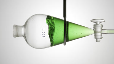 Green transparent liquid injected in funnel, splashes on grey