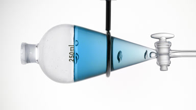 Blue transparent liquid with rising bubbles, grey backdrop
