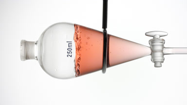 Roselle tea infusion with bubble rising inside separatory funnel
