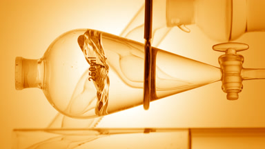 Orange hydrosol injection creates waves in transparent liquid