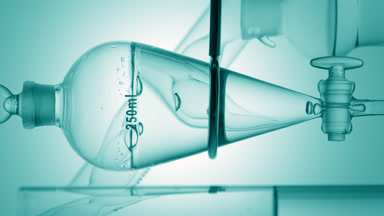 Clear liquid drains, bubbles rise in funnel on cyan ramp