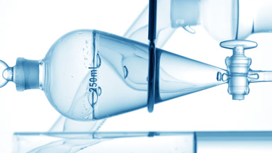 Micellar water drains from funnel, bubbles rising inside view