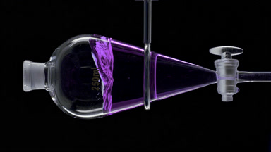 Purple basil hydrosol injected forming vibrant splash in funnel