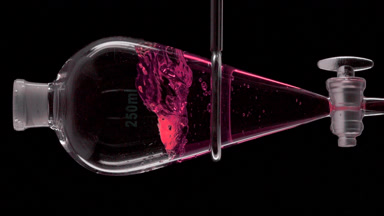 Pink transparent liquid injection forms splashes, black