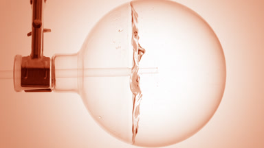 Make-up remover dropper into round flask, swirling bubbles form